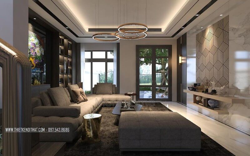 Sắp xếp nội thất phòng khách ấn tượng với cách kết hợp hài hòa giữa sắc trầm và sáng cùng hệ cửa kính lớn giúp không gian trở nên thông thoáng, sang trọng. Thiết kế phòng khách biệt thự